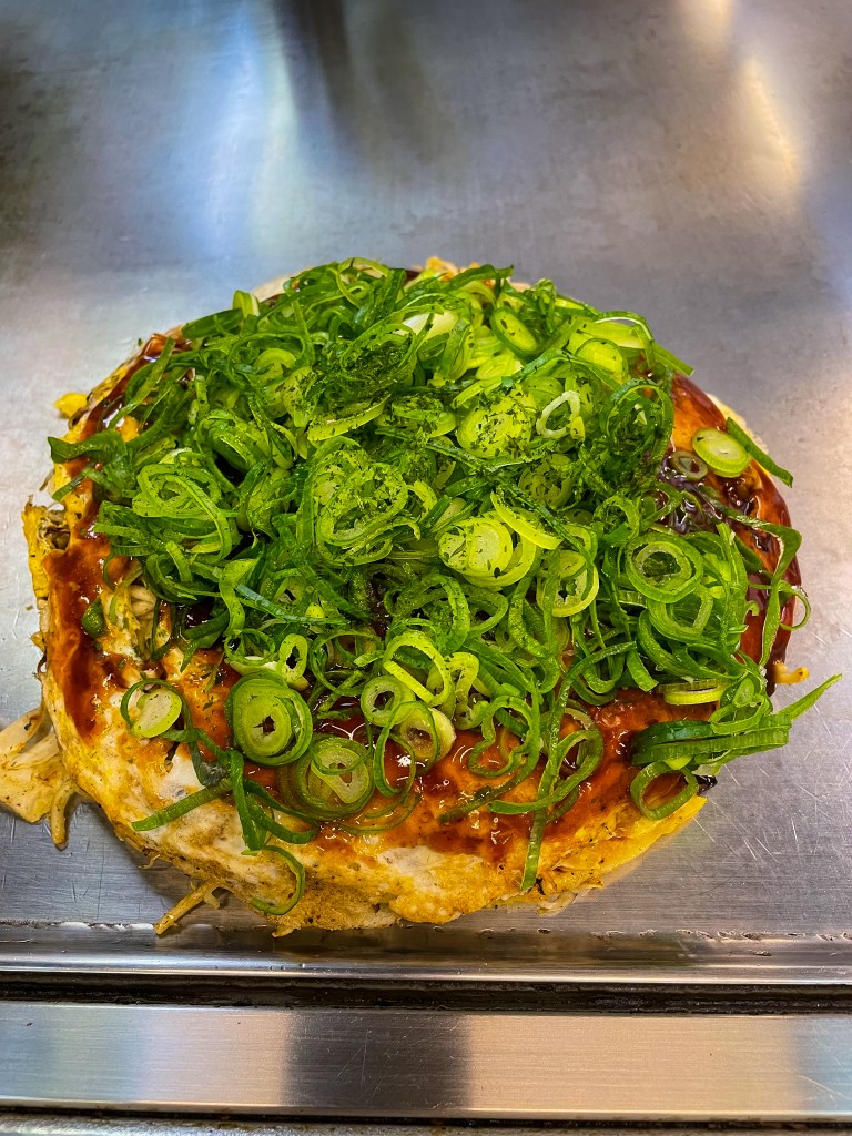 Okonomiyaki on a teppanyaki grill in Okonomimura, Hiroshima, Japan